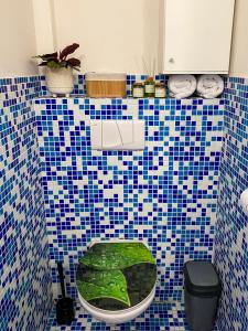 W łazience znajduje się zielona toaleta wyłożona niebieskimi i białymi kafelkami. w obiekcie Pension 311 Vrchlabí w Vrchlabi