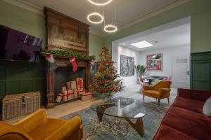 een woonkamer met een kerstboom en een open haard bij Villa Cézar - big house at the center of Bruges - free parking in Brugge