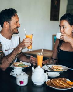 Um homem e uma mulher sentados à mesa a comer. em Villa Ali em Galle