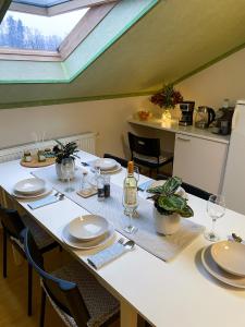 a dining room with a table with plates and glasses at Pension 311 Vrchlabí in Vrchlabí