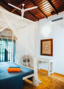 a bedroom with a bed with a mosquito net at Villa Ali in Galle