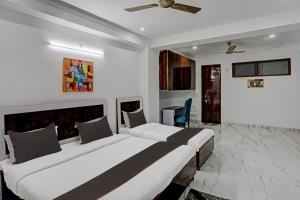 a hotel room with two beds and a desk at Collection O Kanchan Heritage in Gurgaon