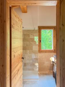 a bathroom with a wooden door and a window at Agriturismo Ai Masi in Combai +15 photos