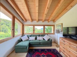 a living room with a green couch and windows at Agriturismo Ai Masi in Combai