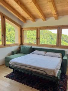 - un lit dans une chambre avec un canapé et des fenêtres dans l'établissement Agriturismo Ai Masi, à Combai