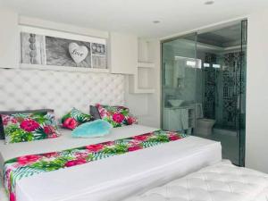 um quarto com uma grande cama branca com flores em Meliyer cheerful 3 bedrooms villa at perebere em Pereybere