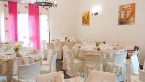 a room filled with white tables and white chairs at Hotel Donna Carmela Sede Unica a Sciacca in Sciacca