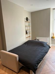 a bedroom with a bed with a black blanket at Old Town City Centre Apartment 2 in Nijmegen