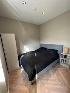 een slaapkamer met een bed met een zwart dekbed bij Old Town City Centre Apartment 2 in Nijmegen