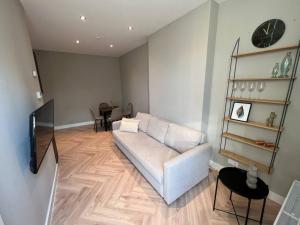 a living room with a white couch and a television at Old Town City Centre Apartment 2 in Nijmegen