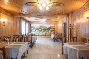 a restaurant with tables and chairs and a painting on the wall at Sadyba u Halyny in Bukovel