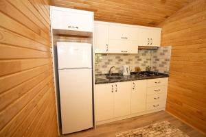 a kitchen with white cabinets and a refrigerator at Eliz Apart & Bungalow in Kumluca