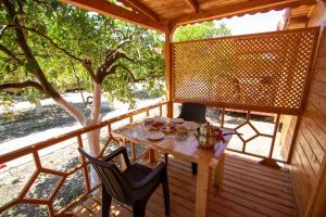 eine Holzterrasse mit einem Tisch und 2 Stühlen in der Unterkunft Eliz Apart & Bungalow in Kumluca