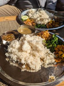 un plato de comida con arroz y verduras en una mesa en Firfirey Organics- Regenerative Farm Retreat, en Bathāla