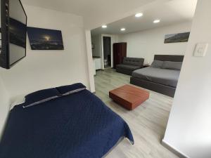 a bedroom with a blue bed and a couch at HOTEL SALITRE STAR in Bogotá