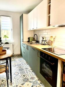 a kitchen with white cabinets and a stove top oven at Apartament Universitate UMFST in Târgu-Mureş
