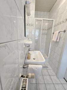 a white bathroom with a sink and a shower at Landgasthaus Sternen in Kehl am Rhein