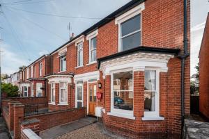 uma casa de tijolos vermelhos com janelas brancas e uma rua em Guest Homes - Sherrington Road Abode em Ipswich