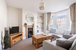 uma sala de estar com um sofá e uma televisão em Guest Homes - Sherrington Road Abode em Ipswich