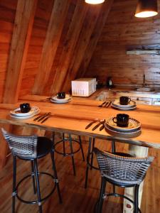 een houten tafel met stoelen en borden eten bij Cabanas Vida no Campo in Santa Maria do Erval