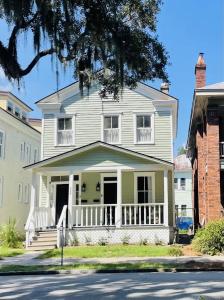 uma casa branca com um alpendre numa rua em Harmony House em Savannah