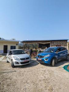 dos coches estacionados frente a un edificio en Firfirey Organics- Regenerative Farm Retreat, en Bathāla