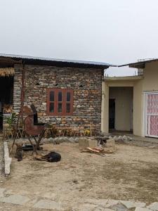una casa de ladrillo con una silla delante en Firfirey Organics- Regenerative Farm Retreat, en Bathāla