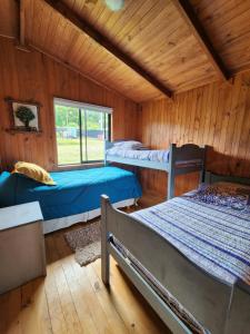 um quarto com três beliches num camarote em Bordelago Lago Lanalhue em Contulmo