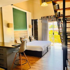 sypialnia z łóżkiem, biurkiem i drabiną w obiekcie Hotel @ Tzaneen w mieście Tzaneen