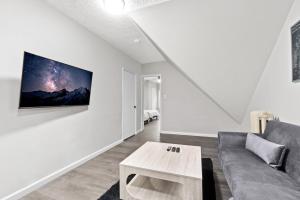 a living room with a couch and a tv on a wall at Epic Spa & Play Retreat NYC EWR Sleeps 30! in Bayonne