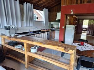 uma cozinha com um balcão de madeira e um frigorífico em Aconchego da Beth em Camanducaia