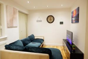 a living room with a couch and a clock on the wall at Flat 3, 2Bed Speedwell, Bristol UK in Bristol