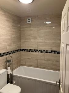 Flat 3, 2Bed Speedwell, Bristol UK في بريستول: حمام مع حوض استحمام ومرحاض