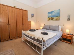 a bedroom with a bed and a dresser at Sea Front Apartment in Hornsea