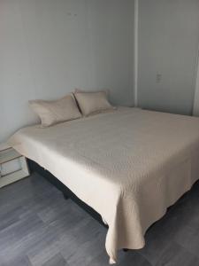 a white bed in a room with a white wall at Casa de vacaciones in Dos de Mayo