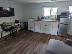 a kitchen with white cabinets and a sink and a table at Cottage near restaurants and trails Slumber Village 5 in Anchorage