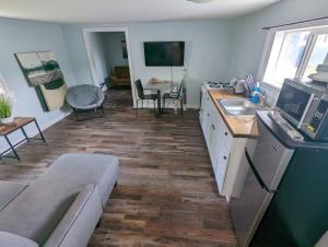 a kitchen and living room with a couch and a sink at Cottage near restaurants and trails Slumber Village 5 in Anchorage