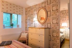 a bedroom with a dresser and a mirror on a wall at Sunday School, Duloe - near Looe, Cornwall, countryside in Liskeard
