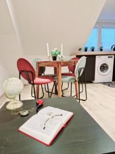 a dining room with a table with red chairs and a tableablish at L'élémentaire, appartement chic et central in Mulhouse