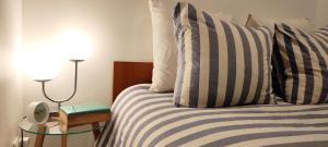 1 cama con 2 almohadas y mesa con lámpara en Cosy Studio aux Batignolles - Proche Montmartre, en París