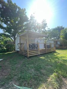 a mobile home with a gazebo in a yard at Camping Beaussement SWEETY in Chauzon