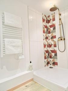 biała łazienka z prysznicem i wanną w obiekcie L'élémentaire, appartement chic et central w Miluzie
