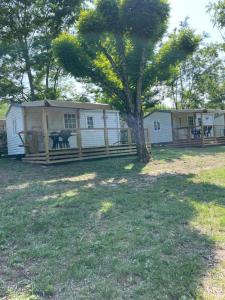 a large white house with a tree in the yard at Camping Beaussement SWEETY in Chauzon +2 photos