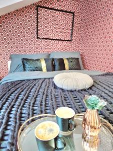 a bed with a table with two cups on it at L'élémentaire, appartement chic et central in Mulhouse