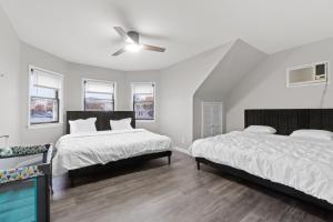 a bedroom with two beds and a ceiling fan at Epic Spa & Play Retreat NYC EWR Sleeps 30! in Bayonne