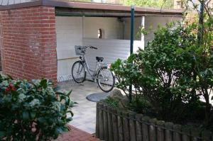 un vélo garé devant un garage dans l'établissement App-West-ARH-132, à Westerland