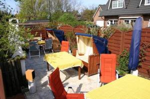 d'une terrasse avec des tables et des chaises et une clôture. dans l'établissement App-West-ARH-132, à Westerland