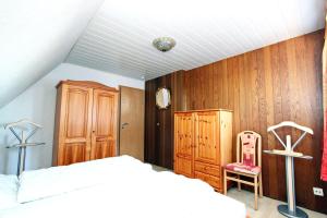 - une chambre avec un lit et un mur en bois dans l'établissement App-West-ARH-132, à Westerland