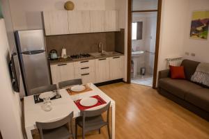 a living room with a kitchen and a table with chairs at Case Vacanze Berton Tirano in Tirano