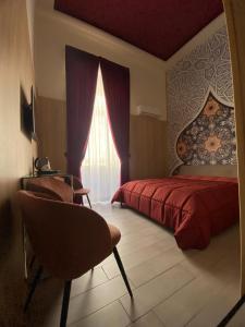 a bedroom with a red bed and a window at Kore Luxury Suite e Spa in Naples